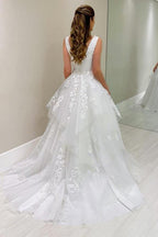 Robe de mariée blanche sans manches en dentelle, coupe trapèze, col en V et appliques, signée par un créateur
