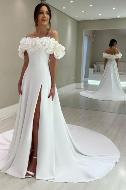 Robe de mariée blanche en satin, coupe trapèze, épaules dénudées, sans manches et fendue.
