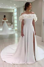 Robe de mariée blanche en satin, coupe trapèze, épaules dénudées, sans manches et fendue.