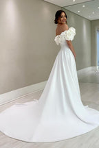 Robe de mariée blanche en satin, coupe trapèze, épaules dénudées, sans manches et fendue.