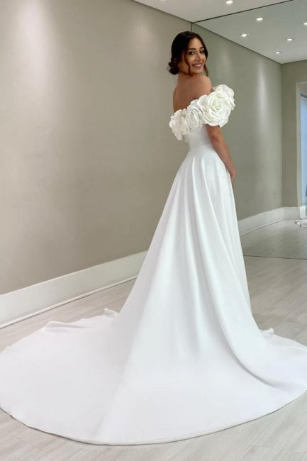 Robe de mariée blanche en satin, coupe trapèze, épaules dénudées, sans manches et fendue.
