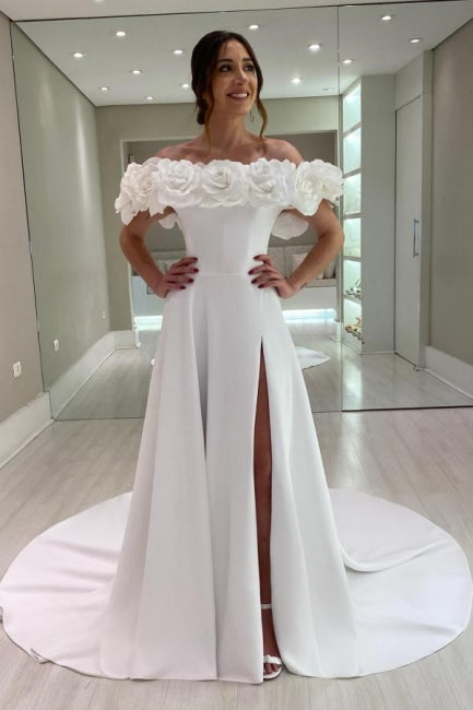 Robe de mariée blanche en satin, coupe trapèze, épaules dénudées, sans manches et fendue.