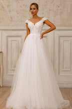 Robe de mariée blanche sans manches en tulle et dentelle, coupe trapèze, col en V, ornée d'appliqués.