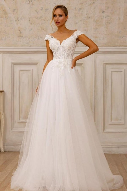 Robe de mariée blanche sans manches en tulle et dentelle, coupe trapèze, col en V, ornée d'appliqués.