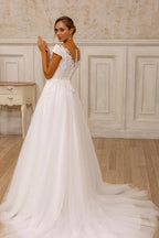 Robe de mariée blanche sans manches en tulle et dentelle, coupe trapèze, col en V, ornée d'appliqués.
