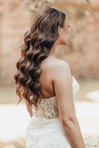 Robe de mariée sirène longue ivoire en dentelle sans bretelles avec traîne.