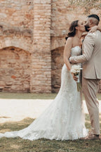 Robe de mariée sirène longue ivoire en dentelle sans bretelles avec traîne.
