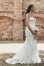 Robe de mariée sirène longue ivoire en dentelle sans bretelles avec traîne.