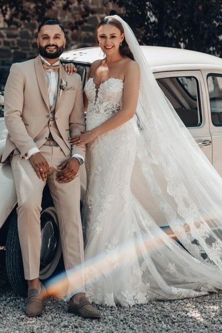 Robe de mariée sirène longue ivoire en dentelle sans bretelles avec traîne.