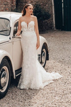Robe de mariée sirène longue ivoire en dentelle sans bretelles avec traîne.