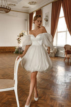 Robe de mariée courte blanche en tulle pailleté à épaules dénudées et manches, signée par un créateur