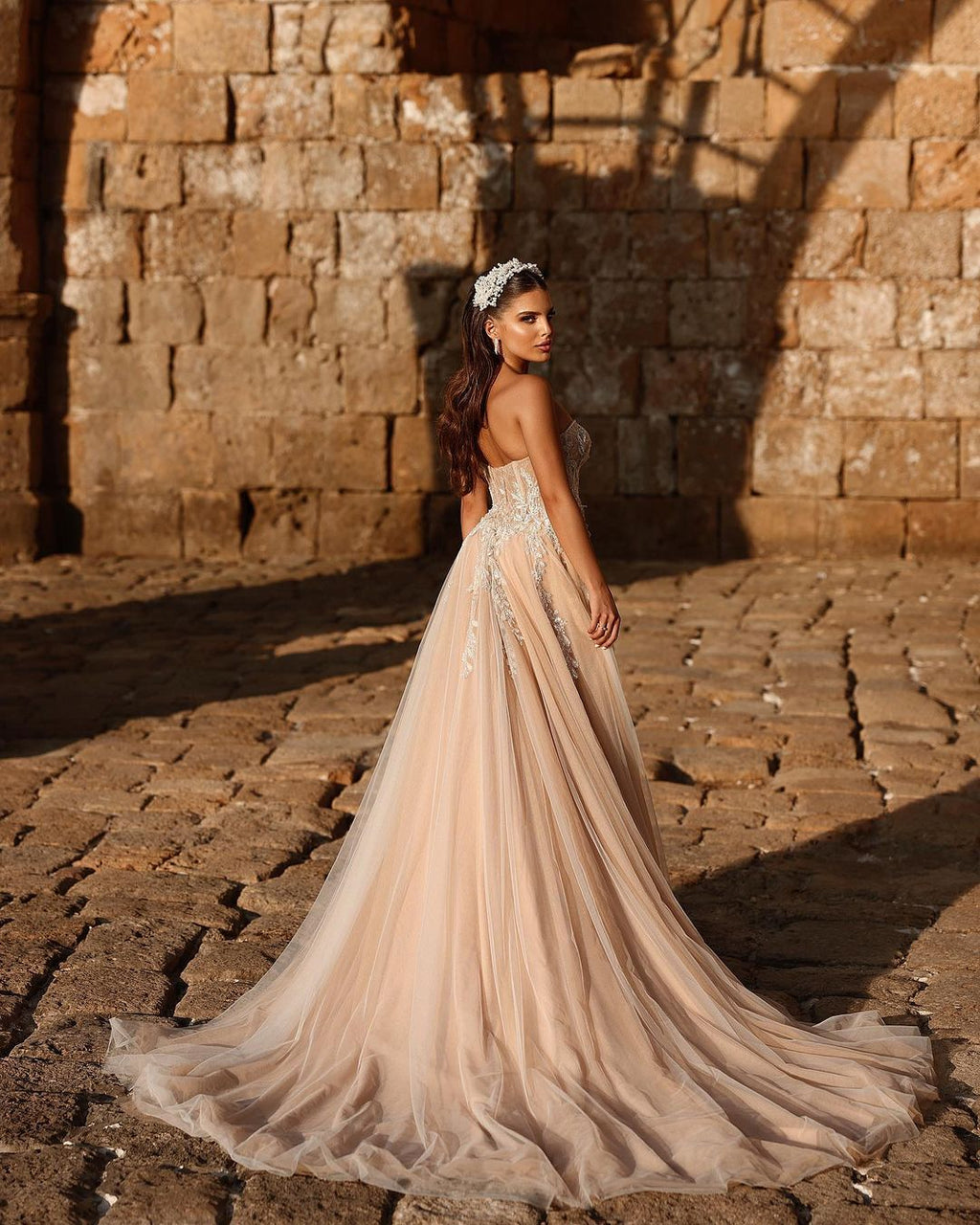 Robe de mariée longue en dentelle pailletée, coupe trapèze, décolleté cœur et fente. Créatrice.