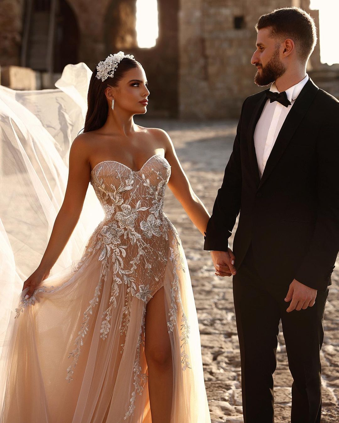 Robe de mariée longue en dentelle pailletée, coupe trapèze, décolleté cœur et fente. Créatrice.