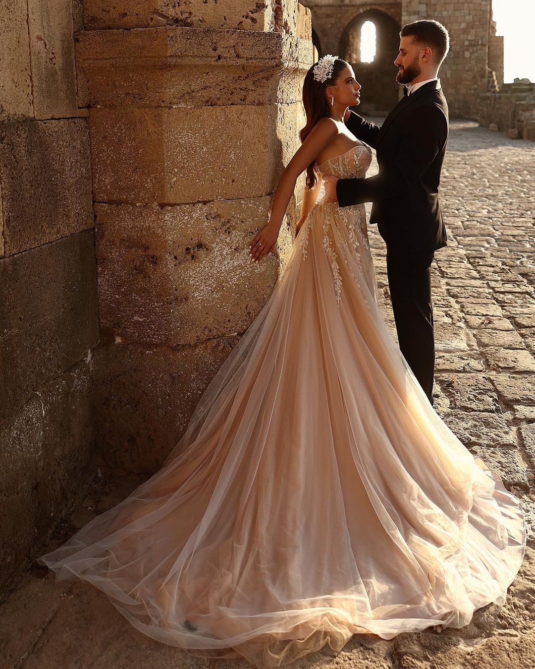 Robe de mariée longue en dentelle pailletée, coupe trapèze, décolleté cœur et fente. Créatrice.