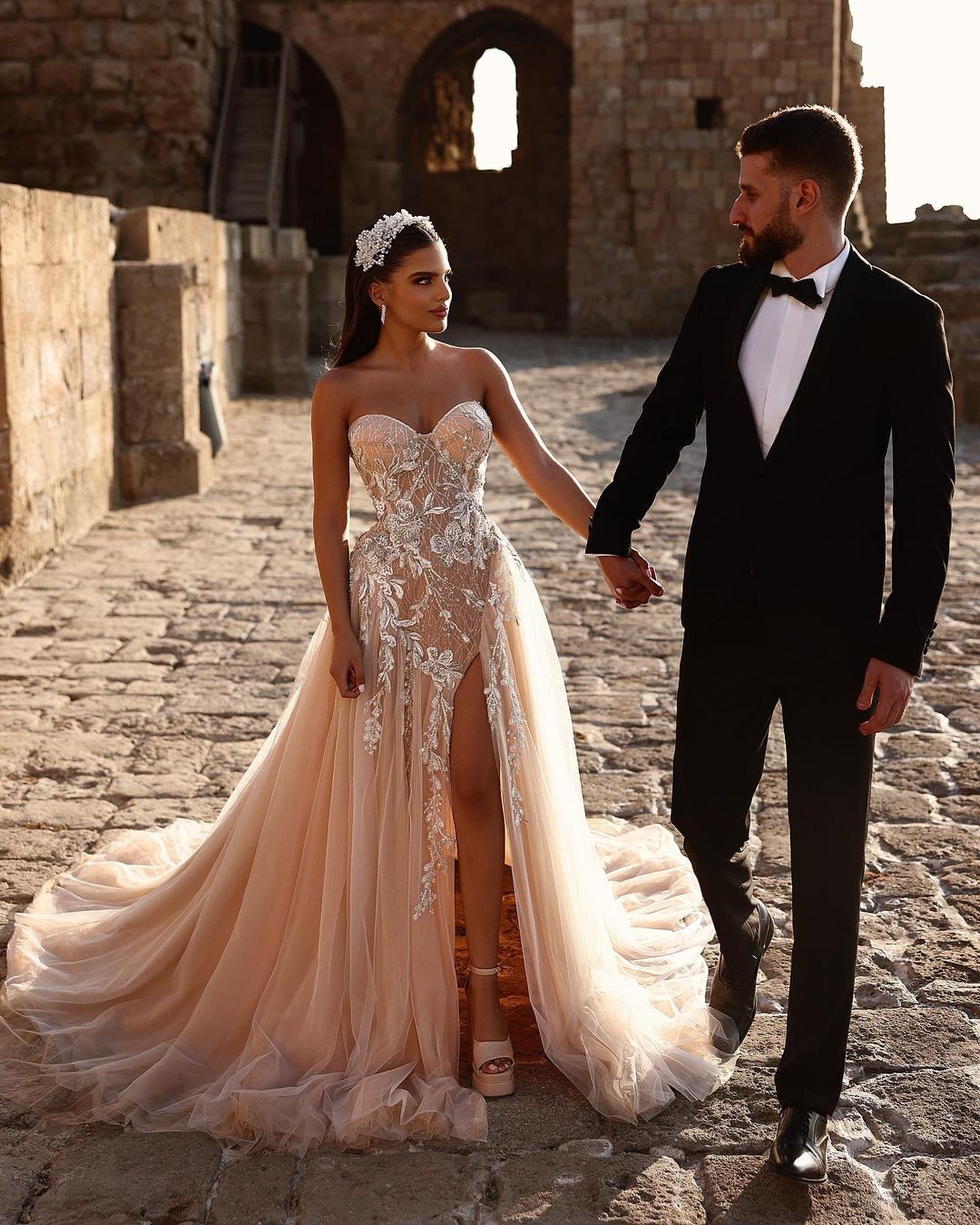 Robe de mariée longue en dentelle pailletée, coupe trapèze, décolleté cœur et fente. Créatrice.
