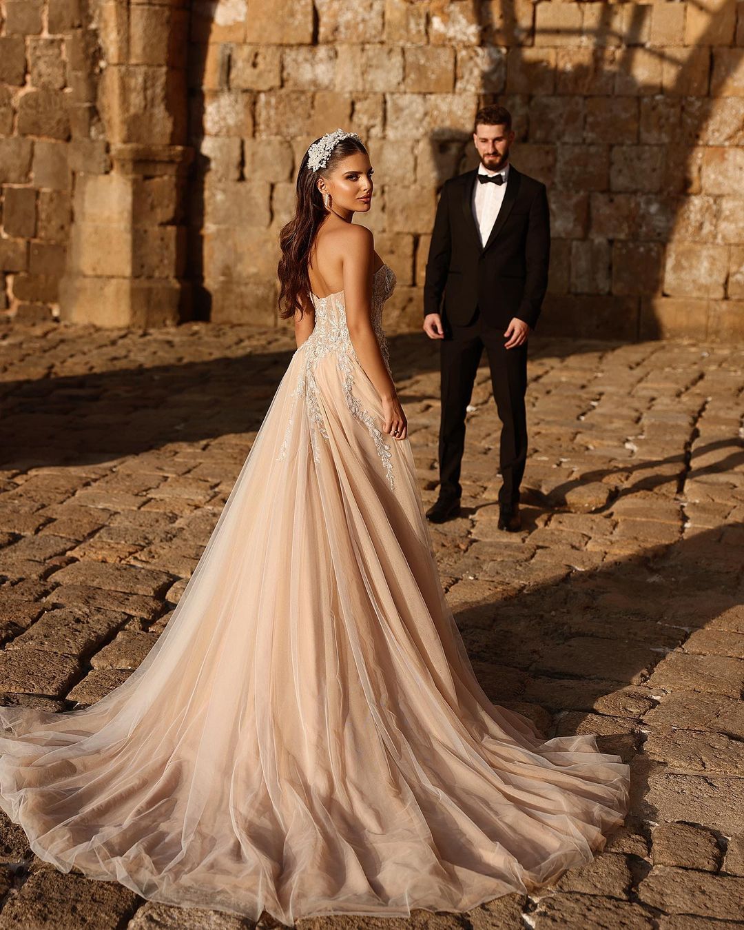 Robe de mariée longue en dentelle pailletée, coupe trapèze, décolleté cœur et fente. Créatrice.