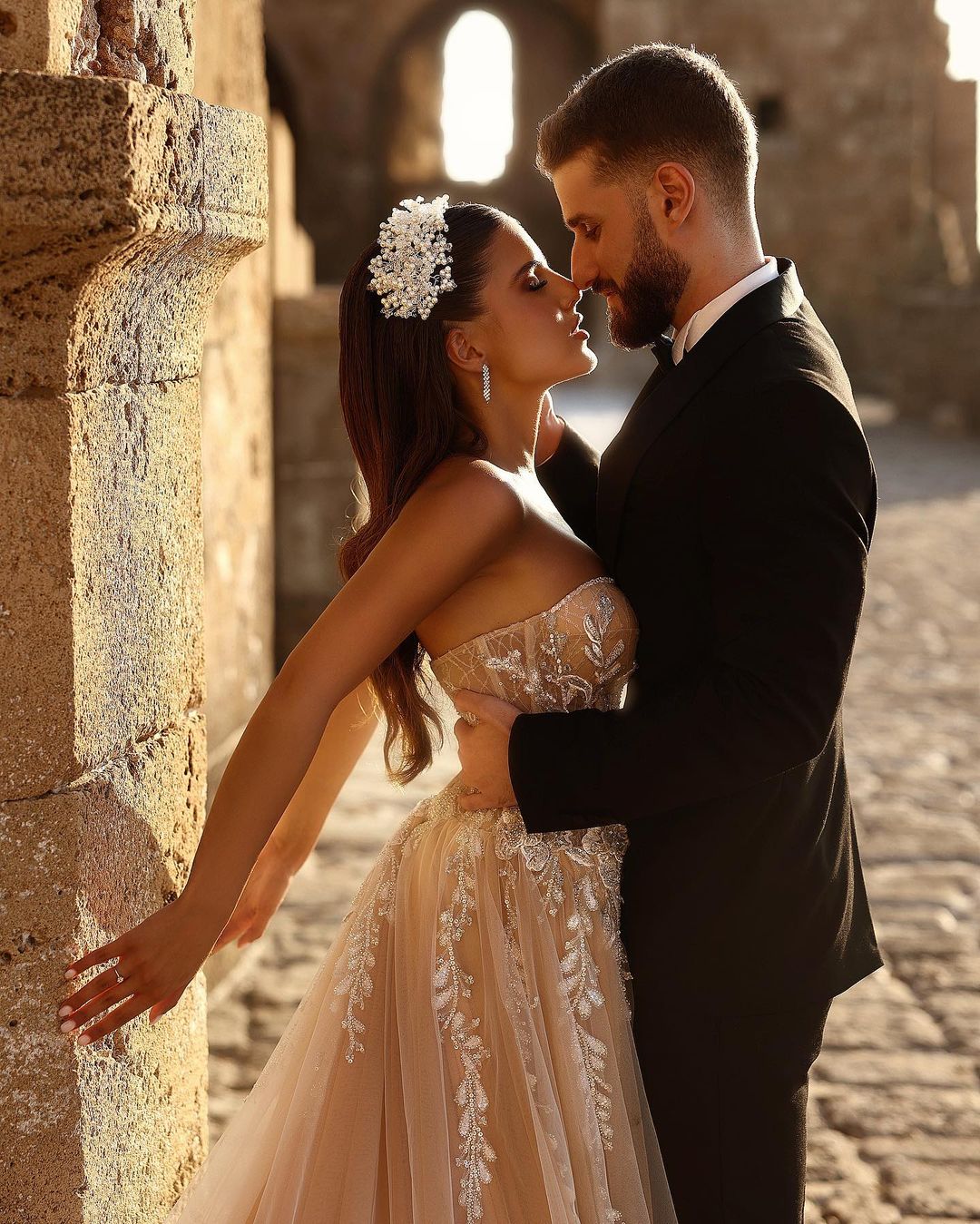 Robe de mariée longue en dentelle pailletée, coupe trapèze, décolleté cœur et fente. Créatrice.