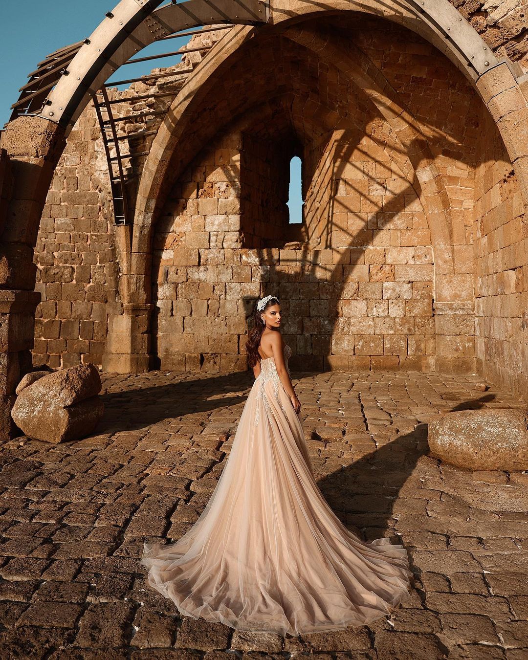 Robe de mariée longue en dentelle pailletée, coupe trapèze, décolleté cœur et fente. Créatrice.