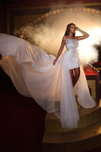Robe de mariée blanche sans manches de créateur, ornée de volants et de dentelle.