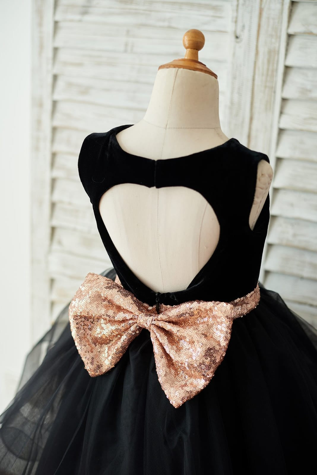Vestido negro de terciopelo con lazo de lentejuelas en forma de corazón en la espalda y largo hasta la rodilla 