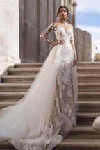 Robe de mariée élégante en dentelle, coupe trapèze, manches longues et traîne amovible.