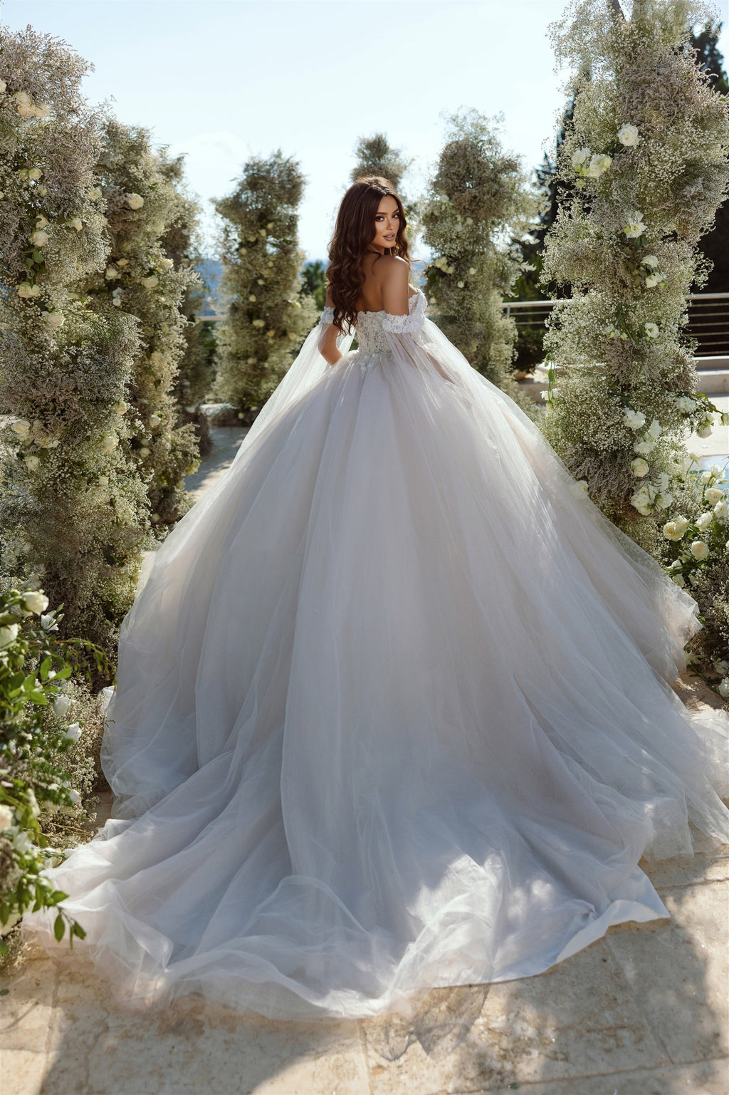 Robe de mariée élégante en tulle et dentelle, coupe trapèze, épaules dénudées, ornée d'appliqués.