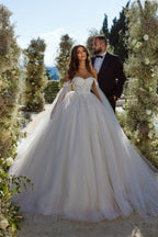 Robe de mariée élégante en tulle et dentelle, coupe trapèze, épaules dénudées, ornée d'appliqués.