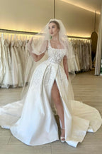 Elegante vestido de novia de encaje sin mangas con tirantes, flores y corte en A, con abertura.