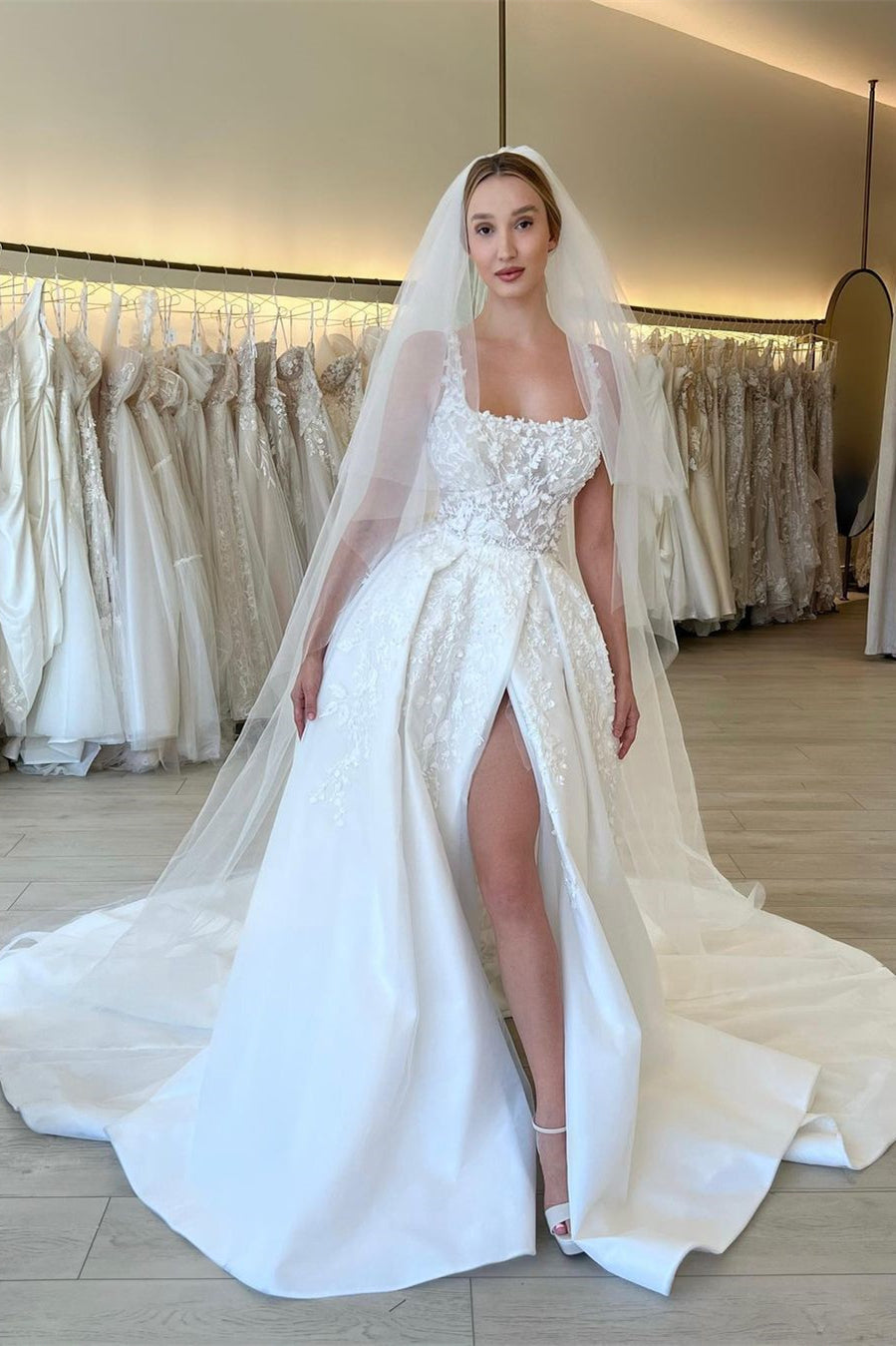 Elegante vestido de novia de encaje sin mangas con tirantes, flores y corte en A, con abertura.