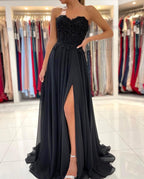 Elegante vestido de fiesta largo negro de corte A, escote corazón, de gasa y abertura.