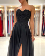 Elegante vestido de fiesta largo negro de corte A, escote corazón, de gasa y abertura.