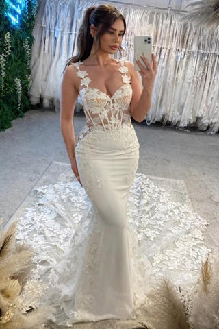Elegante vestido de novia blanco sin mangas, de encaje, con tirantes finos, escote columna y apliques con cola.