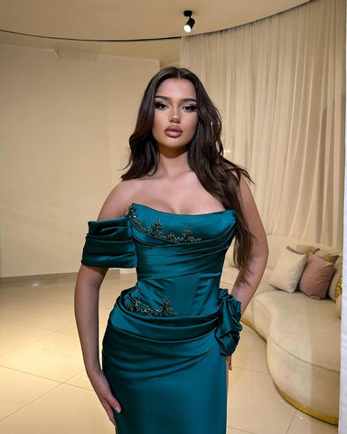 Elegante vestido de fiesta de satén, corte columna, un solo hombro, sin mangas, con apliques y abertura frontal.