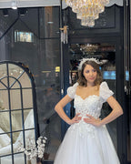 Robe de mariée élégante en tulle, longue jusqu'au sol, décolleté cœur, manches courtes et coupe trapèze, ornée d'une encolure en cœur.