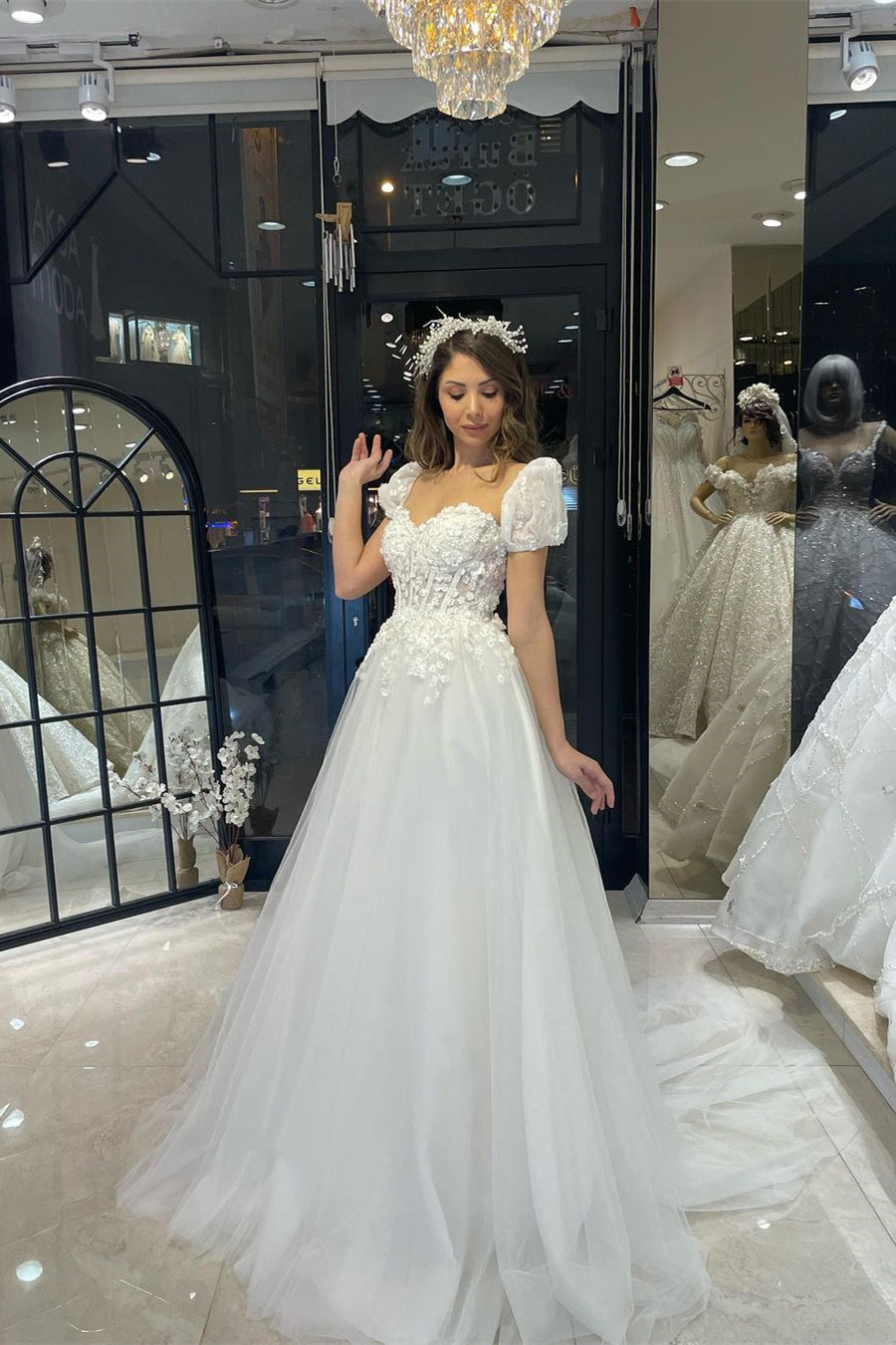 Robe de mariée élégante en tulle, longue jusqu'au sol, décolleté cœur, manches courtes et coupe trapèze, ornée d'une encolure en cœur.