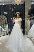 Robe de mariée élégante en tulle, longue jusqu'au sol, décolleté cœur, manches courtes et coupe trapèze, ornée d'une encolure en cœur.