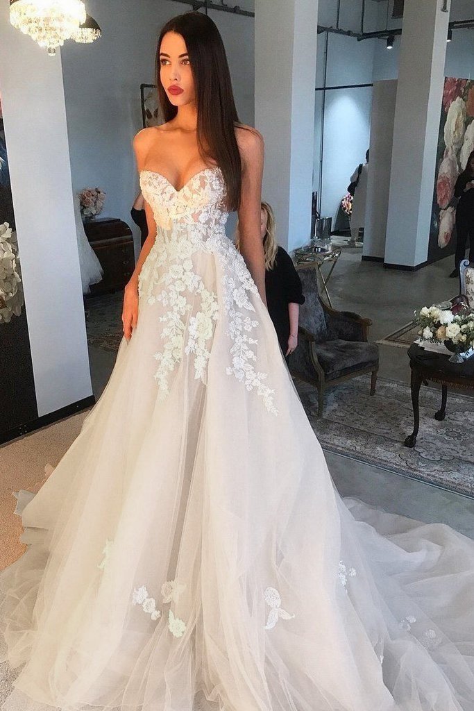 Robe de mariée élégante ivoire longue coupe trapèze, décolleté cœur, en tulle et dentelle appliquée.
