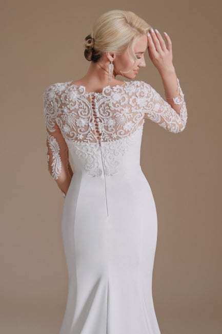 Robe de mariée sirène élégante en satin à manches longues et à motifs, ornée de bijoux. 