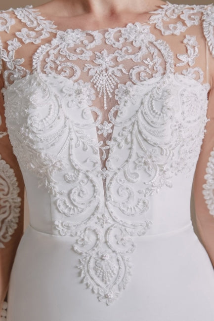 Robe de mariée sirène élégante en satin à manches longues et à motifs, ornée de bijoux. 