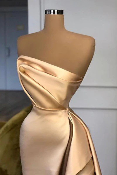 Robe de bal longue élégante, coupe trapèze, couleur champagne, sans bretelles et fendue.