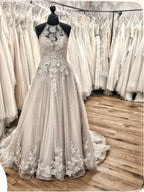 Elegante vestido de novia largo de corte A, escote halter, espalda descubierta, apliques, encaje, tul, volantes y cola