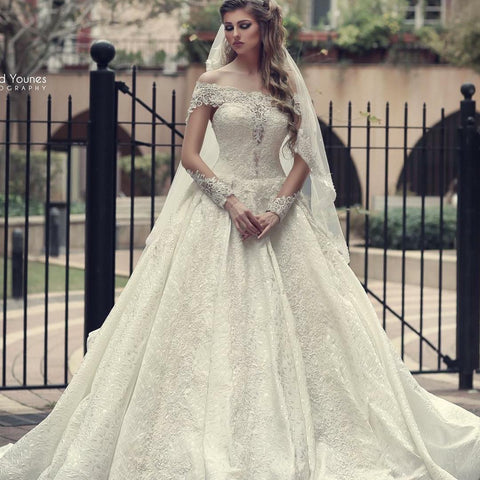 Elegante vestido de novia largo de corte A, con hombros descubiertos, espalda descubierta, apliques de encaje y mangas.