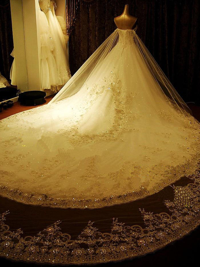 Robe de mariée élégante longue, coupe trapèze, décolleté en cœur, ornée d'appliques et de perles de cristal