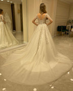 Elegante vestido de novia largo de corte A con escote corazón, apliques de encaje y mangas.