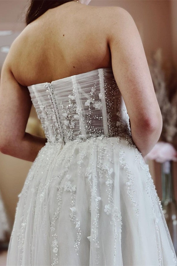 Robe de mariée élégante longue en tulle et dentelle, coupe trapèze, décolleté cœur et fente.