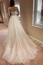 Robe de mariée élégante longue en tulle et dentelle, coupe trapèze, décolleté cœur et fente.