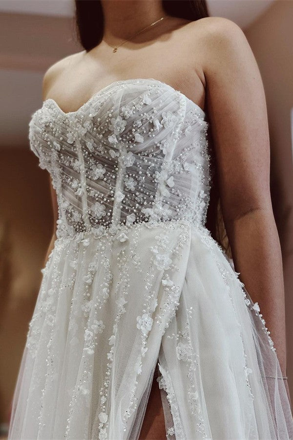 Robe de mariée élégante longue en tulle et dentelle, coupe trapèze, décolleté cœur et fente.
