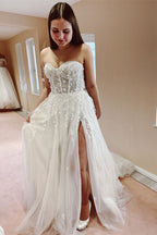 Robe de mariée élégante longue en tulle et dentelle, coupe trapèze, décolleté cœur et fente.