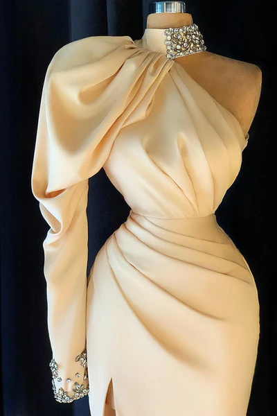 Elegante vestido largo de fiesta color champán con cuello alto, un solo hombro y abertura.