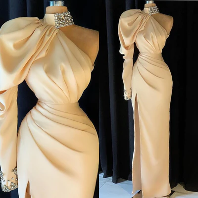 Elegante vestido largo de fiesta color champán con cuello alto, un solo hombro y abertura.